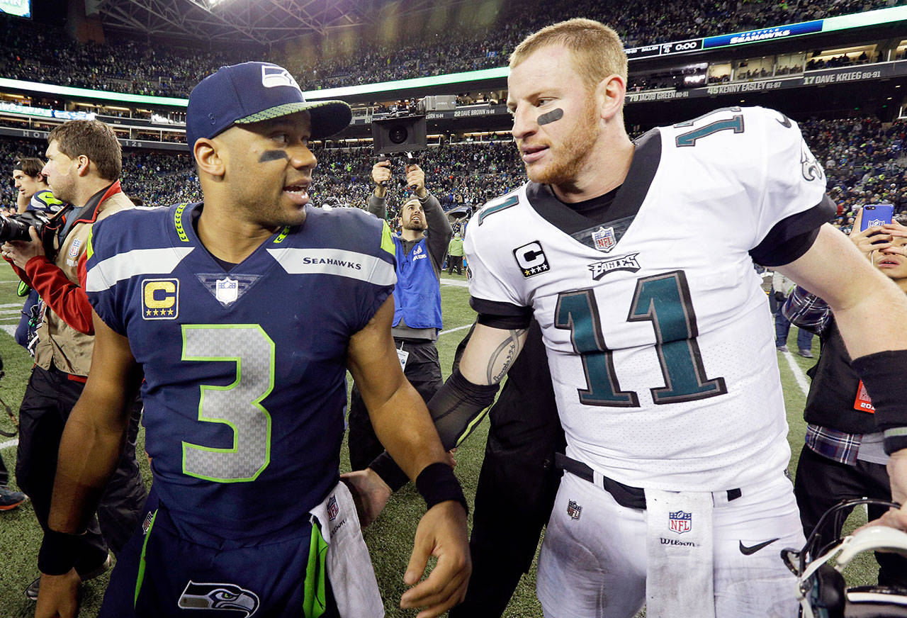 Seattle’s Russell Wilson (3) talks with Philadelphia’s Carson Wentz after a Dec. 3, 2017 game in Seattle. Wilson will be mentoring some of the top prospects in this year’s NFL draft. (AP Photo/Ted S. Warren)