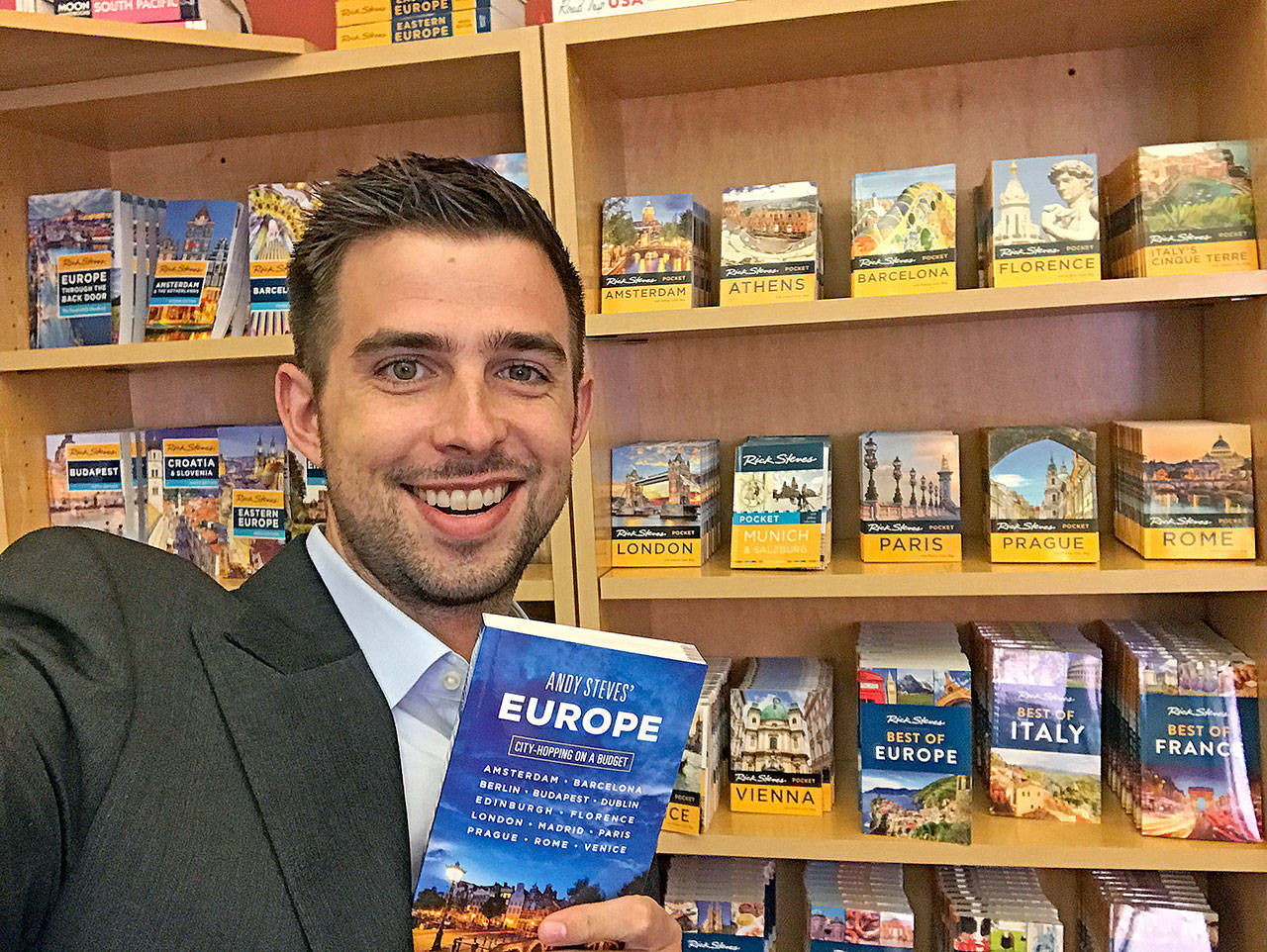 Travel guidebook writer Andy Steves holds a copy of his book “Andy Steves’ Europe: City-Hopping on a Budget.” Steves is the son of Rick Steves, the well-known travel guidebook writer, TV host and tour operator. (Andy Steves)