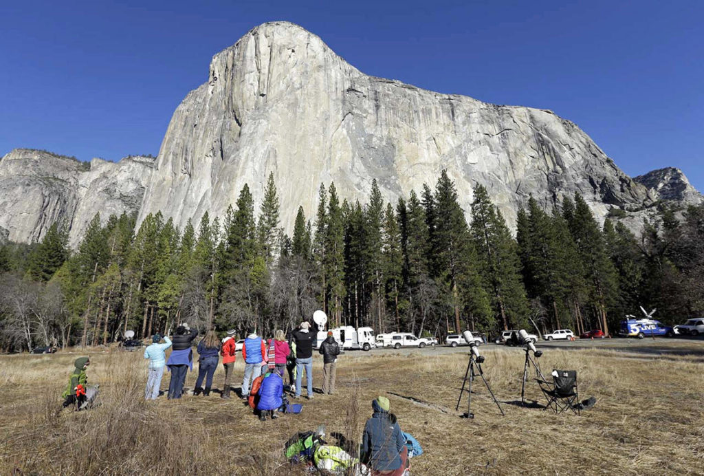 Spectators gaze at El Capitan for a glimpse of climbers, as seen from the valley floor in Yosemite National Park, California. (AP Photo/Ben Margot, File)

