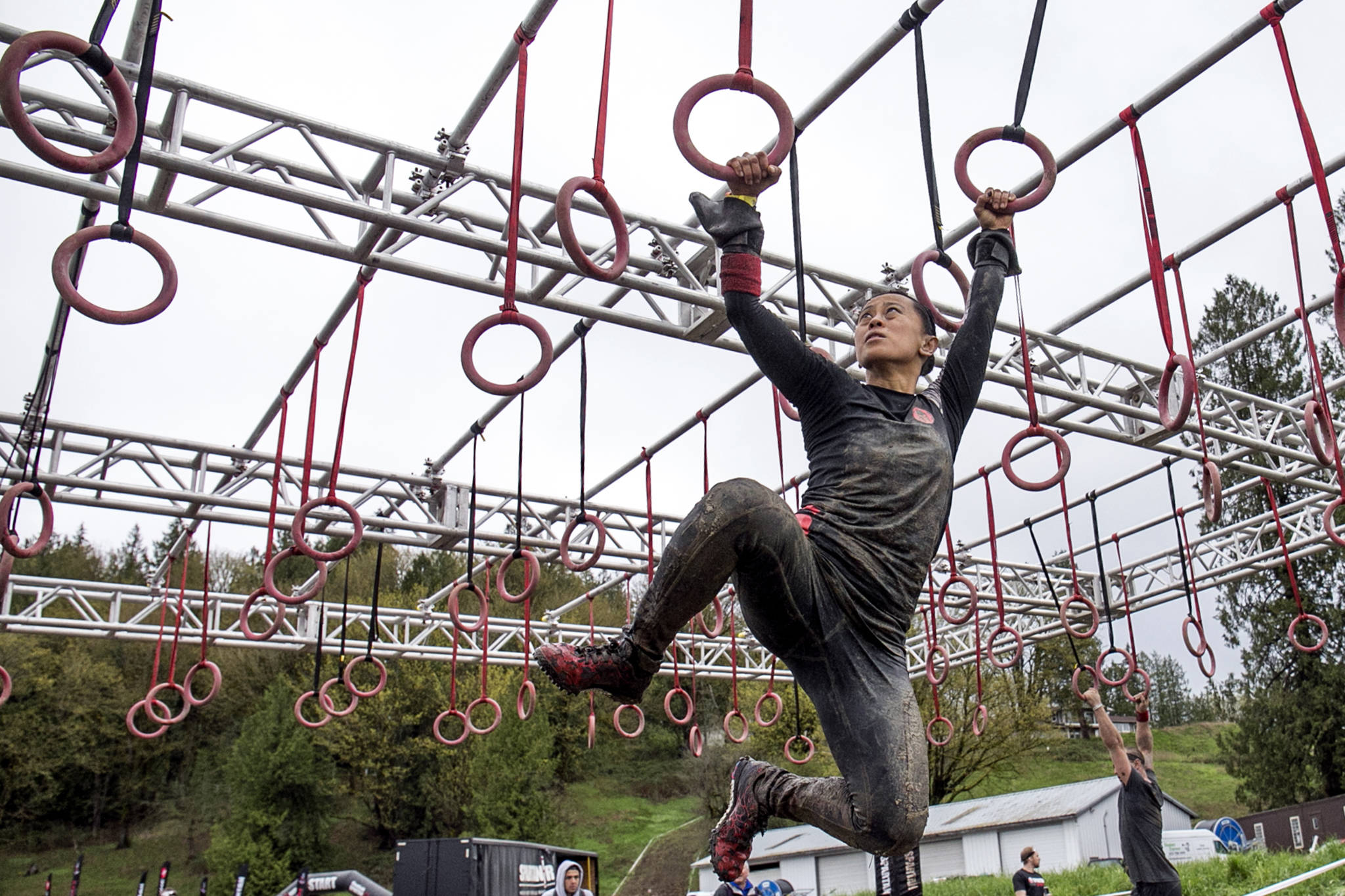A racer make her way across the rings — one of the last obstacles in the Spartan Race and Sprint — Sunday morning in Snohomish. (Kevin Clark / The Herald)