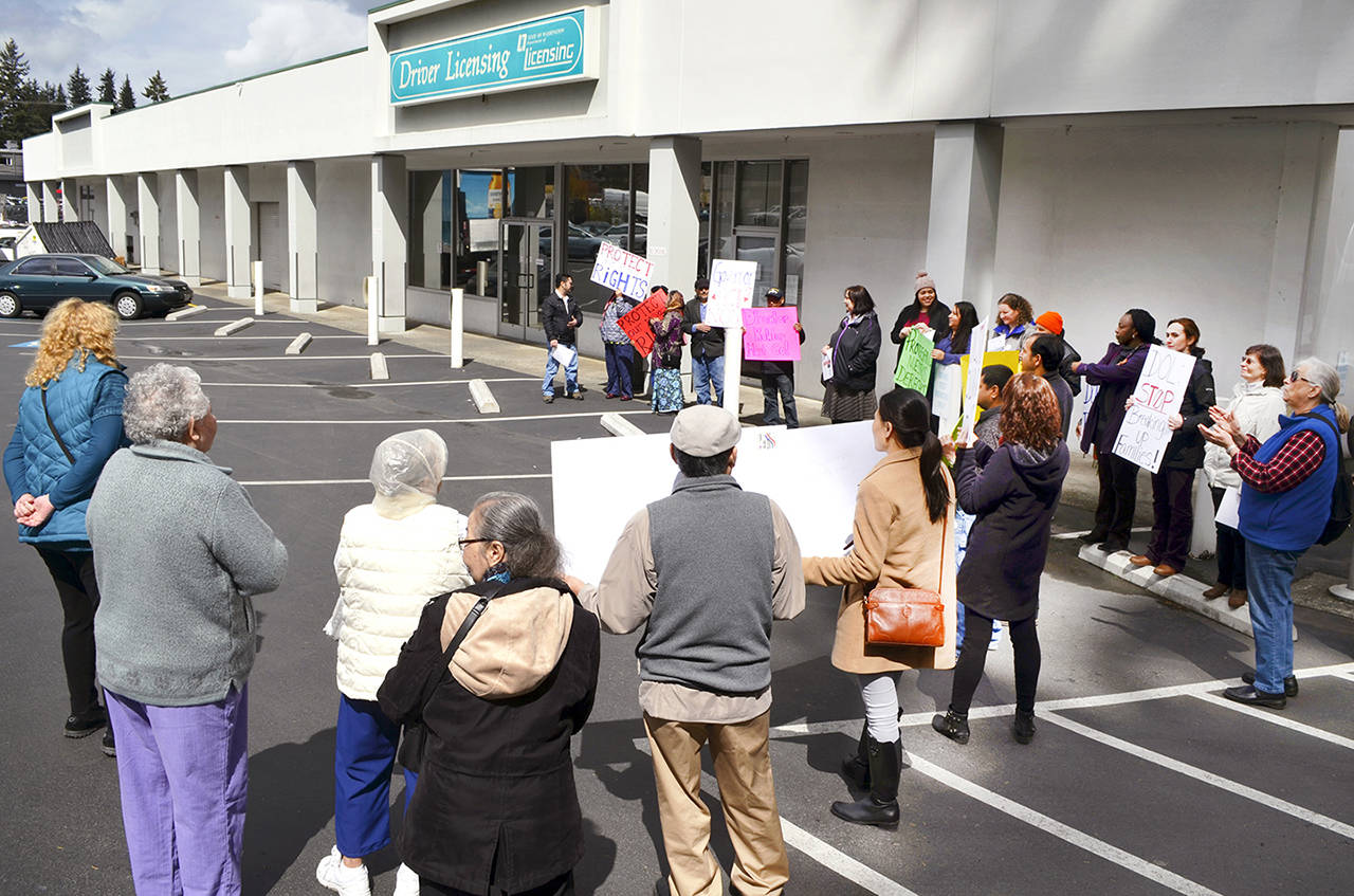 People demonstrate Tuesday at the Everett office against Department of Licensing Director Pat Kohler. The agency was criticized earlier in the year for giving information to Immigration and Customs Enforcement. (Ben Watanabe / The Herald)