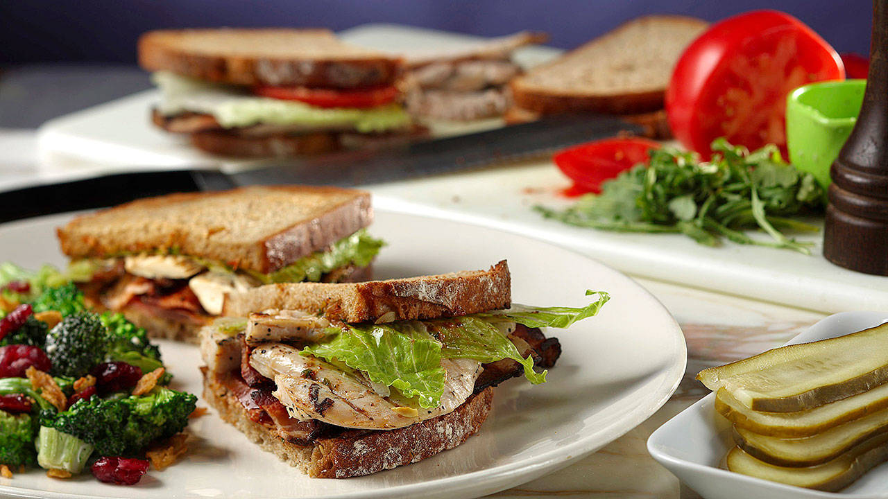 Roast chicken and crispy bacon are layered on thick multigrain bread slices slathered with a sun-dried tomato pesto, chopped arugula, mayo and finshed with romaine. (Abel Uribe/Chicago Tribune)