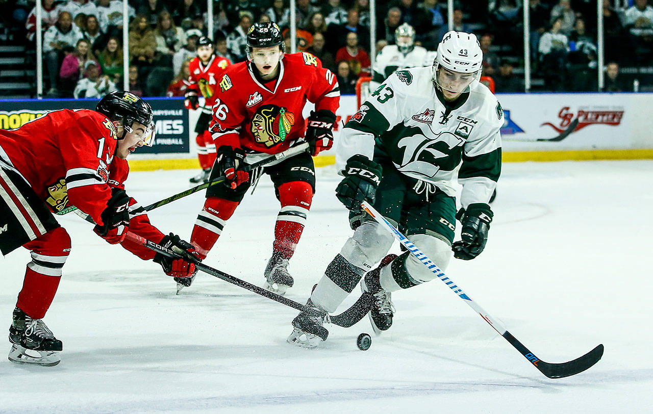 Silvertips center Connor Dewar (right) skates through the Winterhawk defense during a playoff game on April 7, 2018, at Angel of the Winds Arena in Everett. (Ian Terry / The Herald)