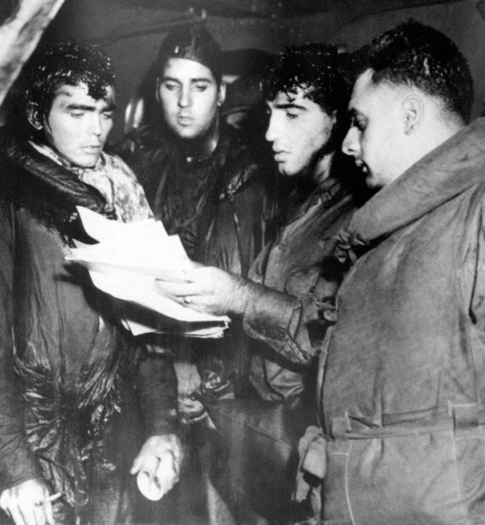 In this July 1943 photo, oil-smeared crew members of the Navy’s light cruiser, USS Helena, “report in” during the battle of Kula Gulf when the Helena was sunk by enemy action. (AP Photo/File)
