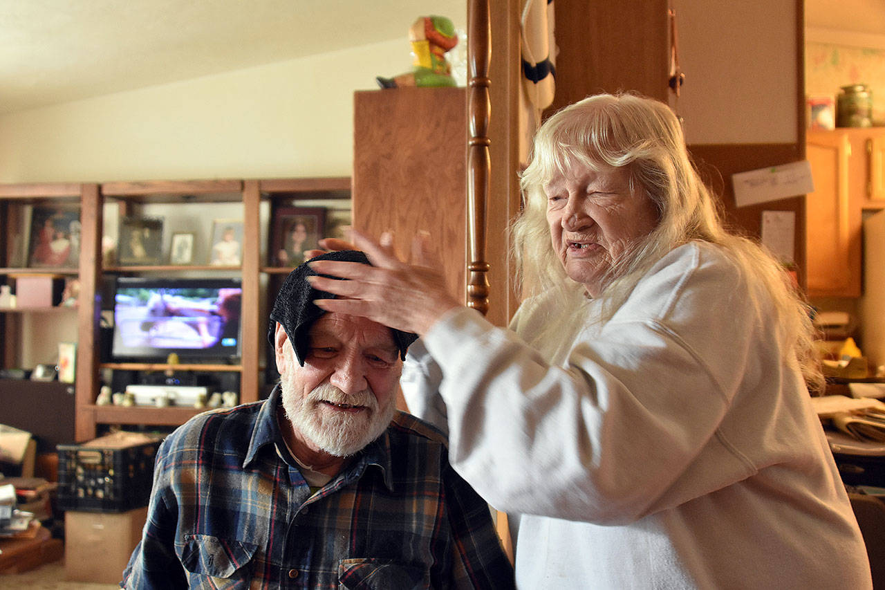 Shirley Fitzpatrick puts a cool towel on the head of her husband, Steve, after he tried to save his friend from a fire at a Marysville mobile home park Wednesday. Ted Shockley, 88, died in the fire. (Caleb Hutton / The Herald)