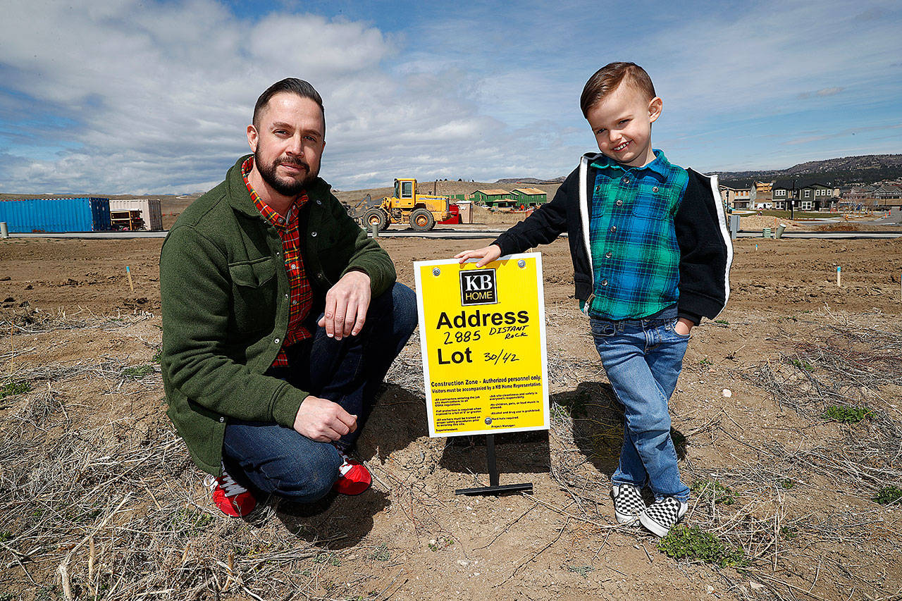Chad Zolman joins his 5-year-old son, Quinten, at the site of their yet-to-be-built new home in Castle Rock, Colorado, on April 7. (AP Photo/David Zalubowski)