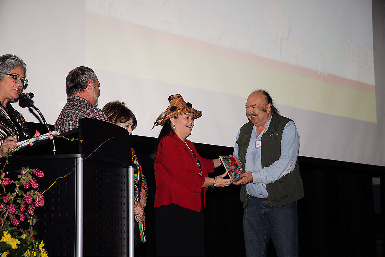 Terry Williams of Tulalip Tribes receives the Snohomish Conservation District Lifetime Achievement Award from Councilwoman Bonnie Juneau. Standing nearby are Williams’ wife, Sue; Mark Craven, Snohomish Conservation District board chair; and at the microphone is Maia Bellon, Washington Department of Ecology director. (Contributed photo)