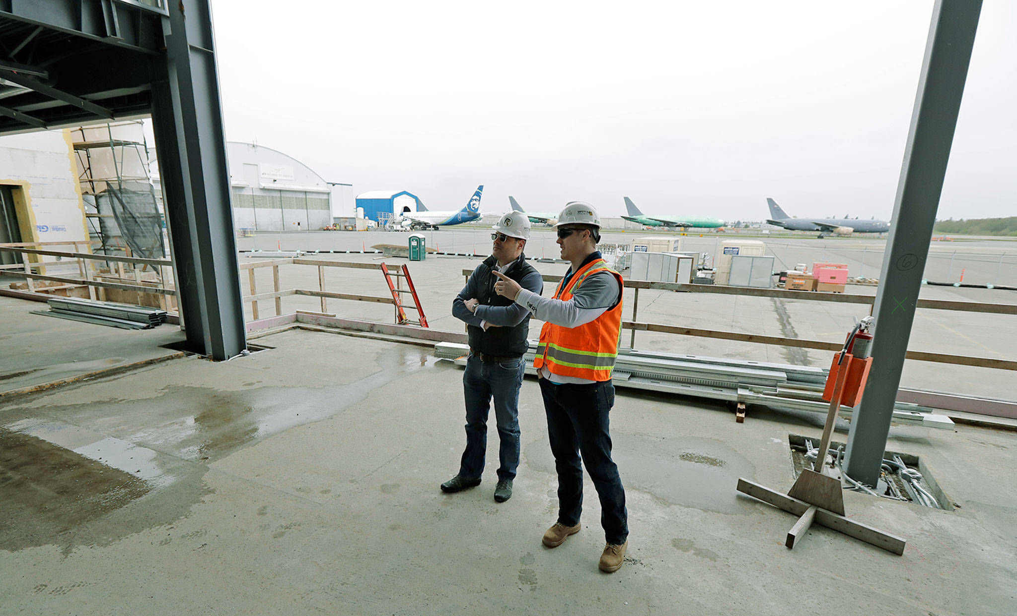 Brett Smith (left), CEO of Propeller Airports, talks with project engineer Todd Raynes inside the new passenger terminal at Paine Field in Everett. (AP Photo/Ted S. Warren)