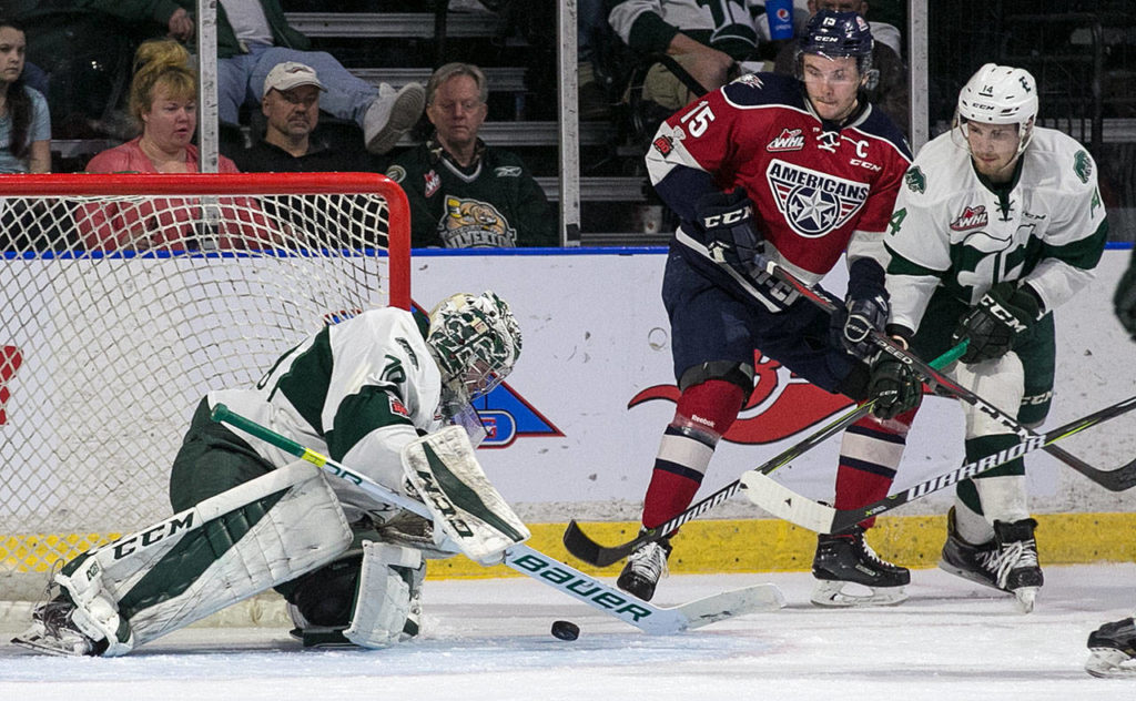 Silvertips goalie Carter Hart (left) stops a shot with teammate Riley Sutter (far right) and the Americans’ Michael Rasmussen looking on during Game 1 of the Western Conference finals on April 20, 2018, at Angel of the Winds Arena in Everett. (Kevin Clark / The Herald)
