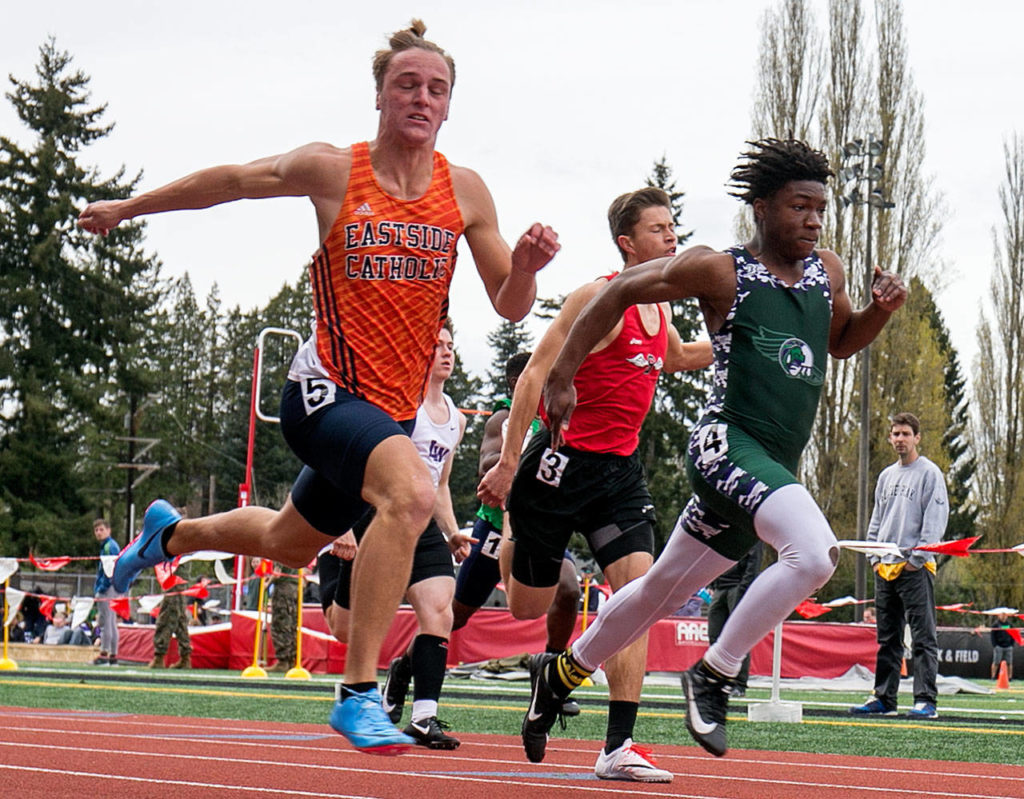 Eastside Catholic’s David Pritchard (left) leans to capture the win ahead of Edmond-Woodway’s Chinedu Acholonu in the 100-meters at the annual Larry Eason Invitational on April 21, 2018, at Veterans Memorial Stadium in Snohomish. (Kevin Clark / The Herald)
