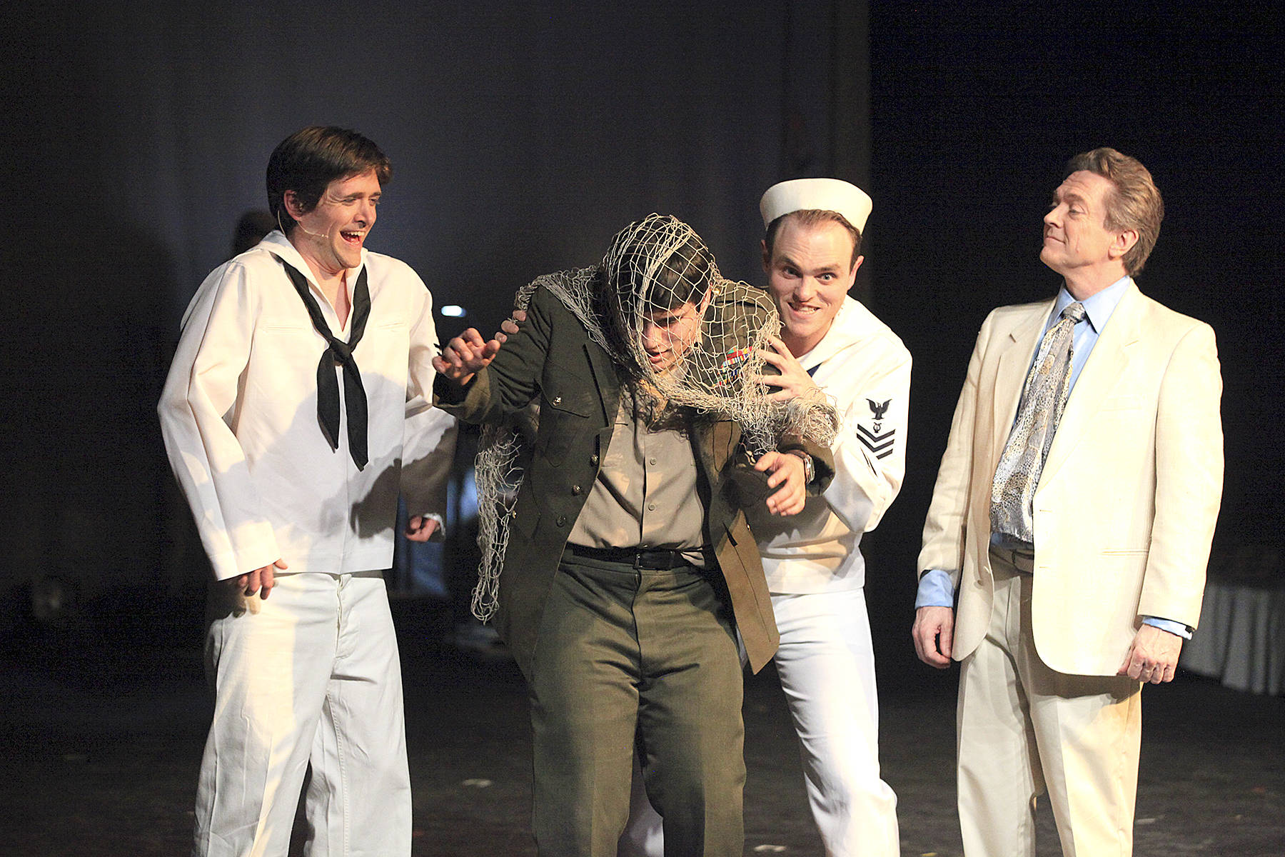 Lawrence (Jay Vilhauer), right, has Freddy (Gabriel Ponce) hauled away by some sailors in Edmonds Driftwood Players’ production of “Dirty Rotten Scoundrels,” showing at the Wade James Theatre through May 12. (Edmonds Driftwood Players)