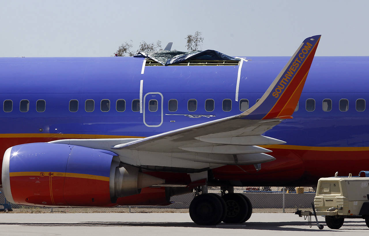 In this April 4, 2011 photo, a Southwest Airlines plane sits in a remote area of the Yuma International Airport, after the plane had a section of fuselage tear from the plane during a flight in Yuma, Arizona. (AP Photo/Ross D. Franklin, File)