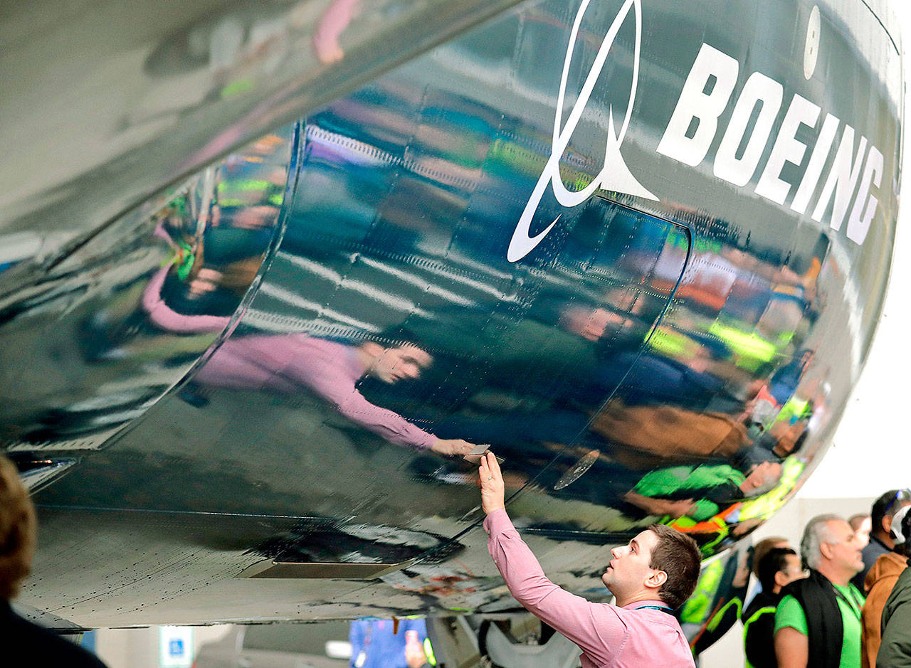 Boeing worker Paul Covaci reaches out to touch a Boeing 737 MAX 7, the newest version of Boeing’s fastest-selling airplane, on Feb. 5 during an unveiling for employees and media in Renton. (AP Photo/Elaine Thompson, File)