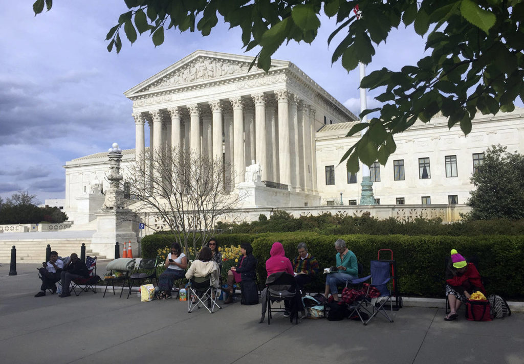 People wait in line outside the Supreme Court in Washington on Monday to be in the gallery when the court hears arguments Wednesday over President Donald Trump’s ban on travelers from several mostly Muslim countries. (AP Photo/Jessica Gresko)
