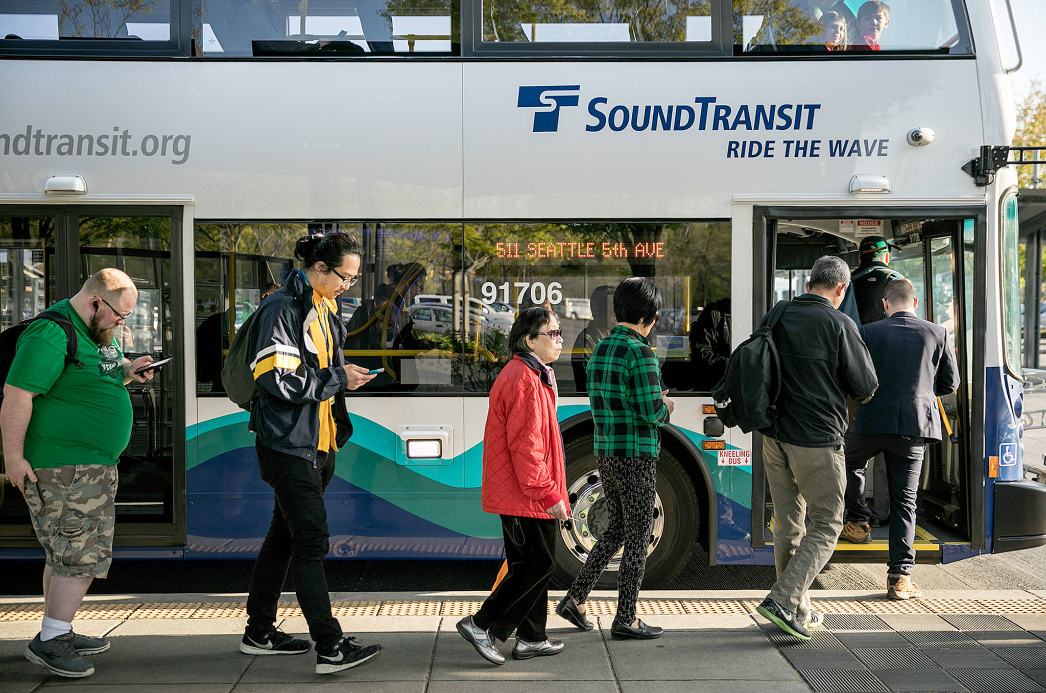 While Sound Transit buses have grown in size to meet demand, capacity at park-and-ride lots in Snohomish County has barely changed. Riders board a Seattle bound bus at the Lynnwood Transit Center Thursday. (Lizz Giordano / The Herald)