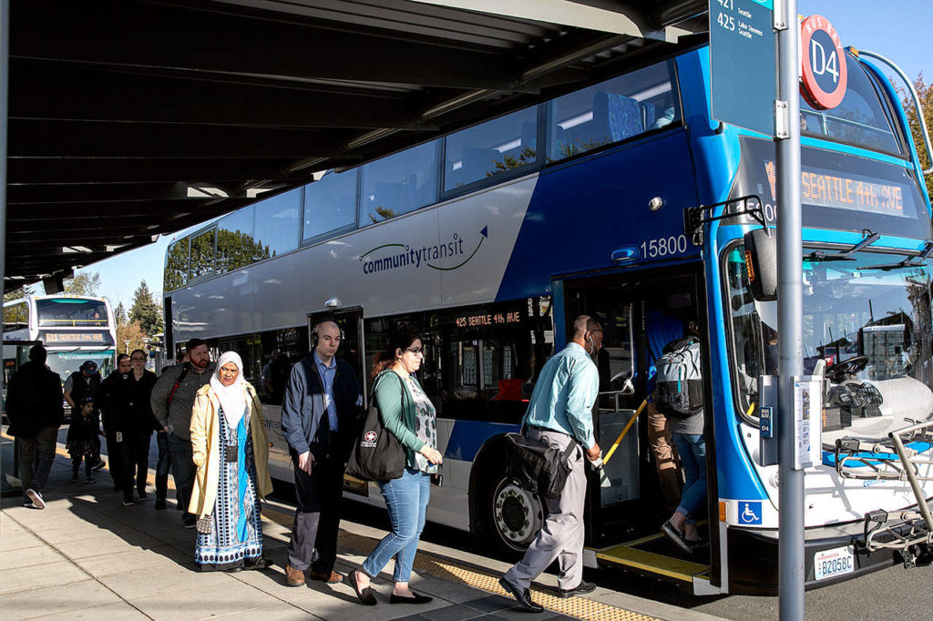 While Sound Transit buses have grown in size to meet demand, capacity at park-and-ride lots in Snohomish County has barely changed. Riders board a Seattle-bound bus at the Lynnwood Transit Center Thursday. (Lizz Giordano / The Herald) 
