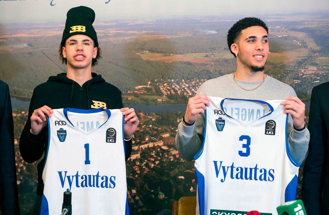 In this Jan. 5, 2018, photo, basketball players LiAngelo Ball (right) and LaMelo Ball show hold up their jereseys after signing with BC Prienai Vytautas. (AP Photo/Mindaugas Kulbis, File)