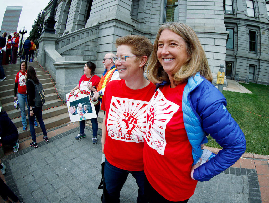 Kerrie Dallman (left), president of the Colorado Education Association, jokes with Cary Kennedy, a candidate for the Democratic nomination to run for Colorado’s governorship, during a teacher rally Thursday in Denver. (AP Photo/David Zalubowski)
