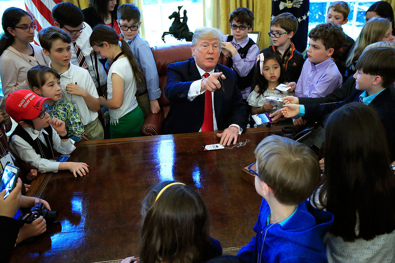 President Donald Trump is surrounded by kids in the Oval Office in celebration of “Bring Our Daughters and Sons to Work Day” at the White House in Washington on Thursday. (AP Photo/Manuel Balce Ceneta)
