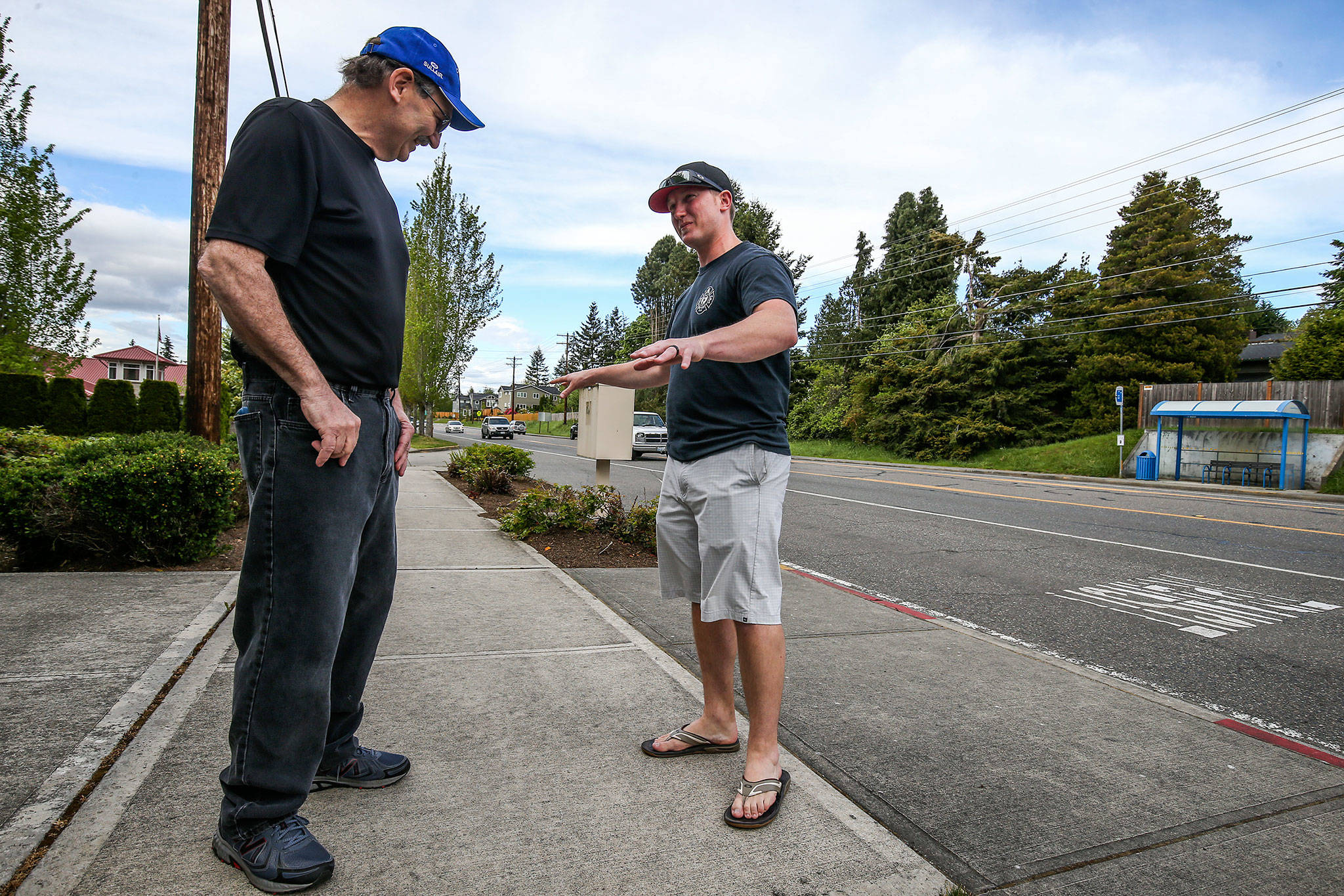 George Safadago listens as Mukilteo Fire Department paramedic Brian Ouellette explains how Safadago was laid out on the sidewalk, after suffering a heart attack, on Wednesday, May 9, in Mukilteo. On March 7 Safadago suffered the heart attack and Ouellette, a former baseball player for Safadago, saved his life performing CPR. (Andy Bronson / The Herald)