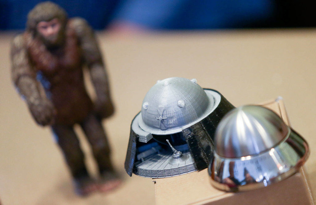 A sasquatch and two spaceships decorate the table during a meeting of the UFOiTeam at the Denny’s in Lynnwood for live streaming discussions. (Andy Bronson / The Herald)
