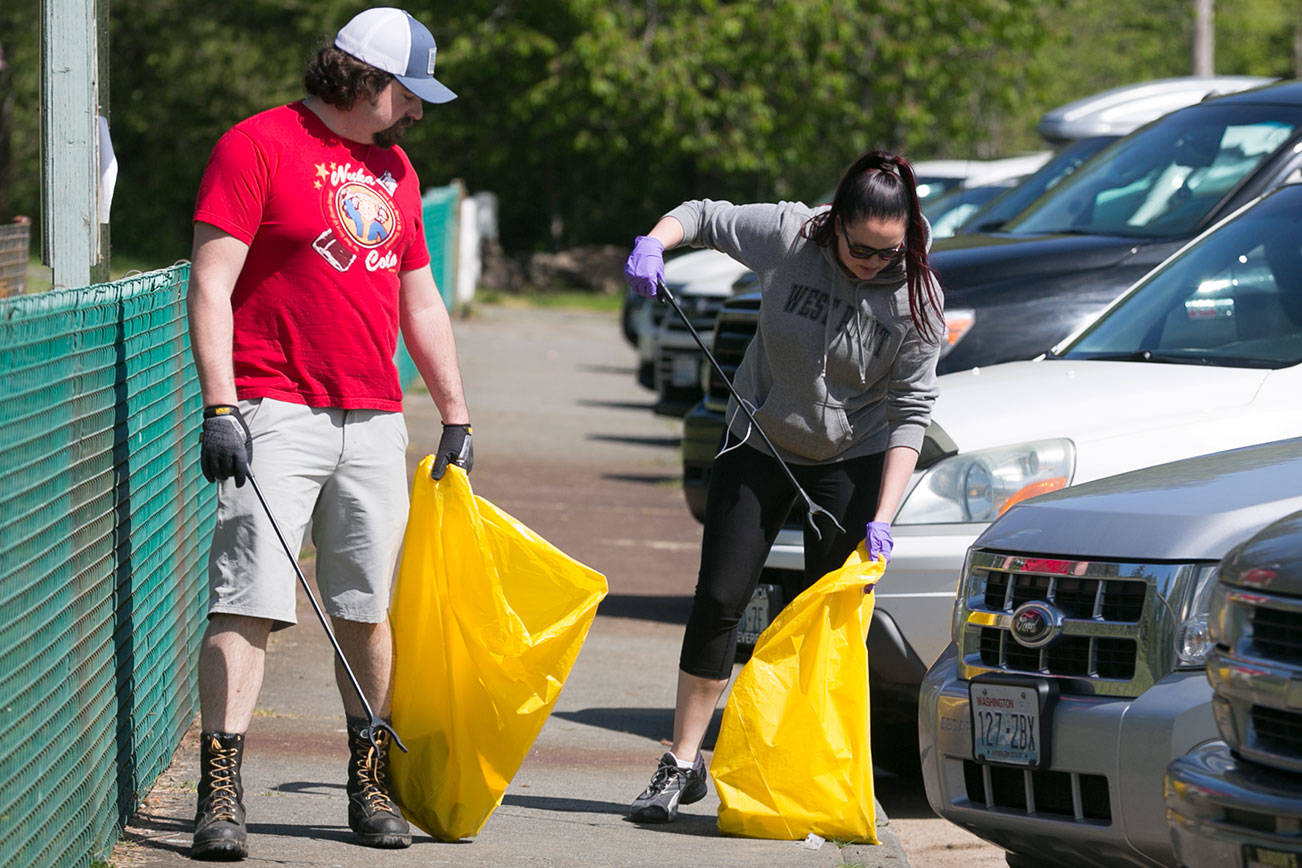 Clinton Oakland looks on as his wife, Jackie Oakland, gathers trash after their Pokemon Go Raid Battles Saturday morning at Osprey Park in Sultan on May 5, 2018. (Kevin Clark / The Herald)