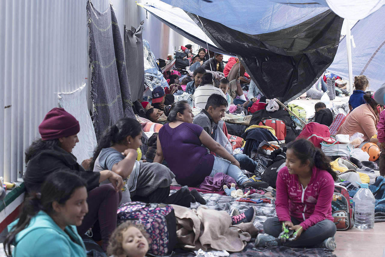 People who traveled with the annual caravan of Central American migrants rest where the group set up camp to wait for access to request asylum in the U.S., outside the El Chaparral port of entry building at the US-Mexico border in Tijuana, Mexico, on Monday. (AP Photo/Hans-Maximo Musielik)