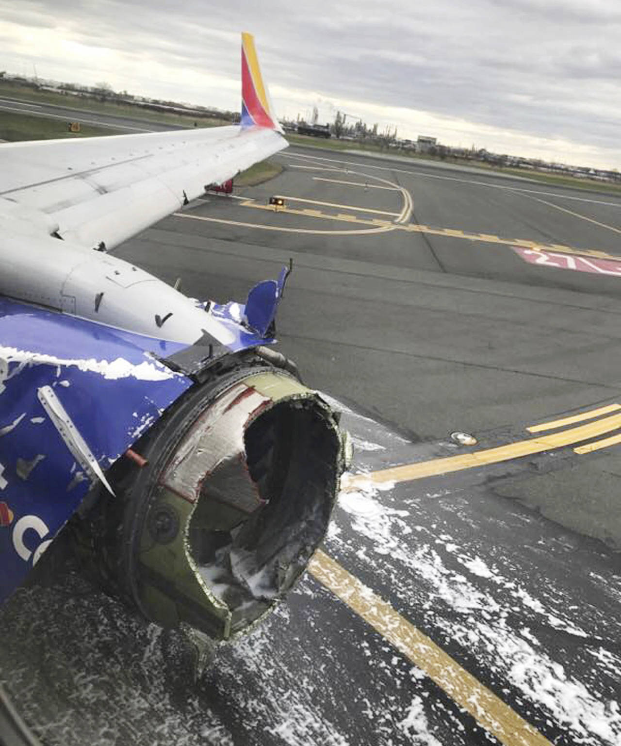 This April 17 photo shows the jet engine casing of a Southwest Airlines airplane after pilots of the twin-engine Boeing 737 bound from New York to Dallas with 149 people aboard took it into a rapid descent and made an emergency landing in Philadelphia. (Marty Martinez via AP)
