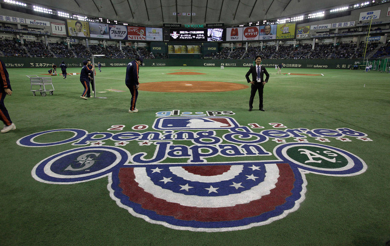 In this photo from March 28, 2012, the ground staff works to get the field ready prior to the 2012 Major League Baseball season opener between the Oakland Athletics and the Seattle Mariners at Tokyo Dome in Tokyo. (AP Photo/Shizuo Kambayashi, File)