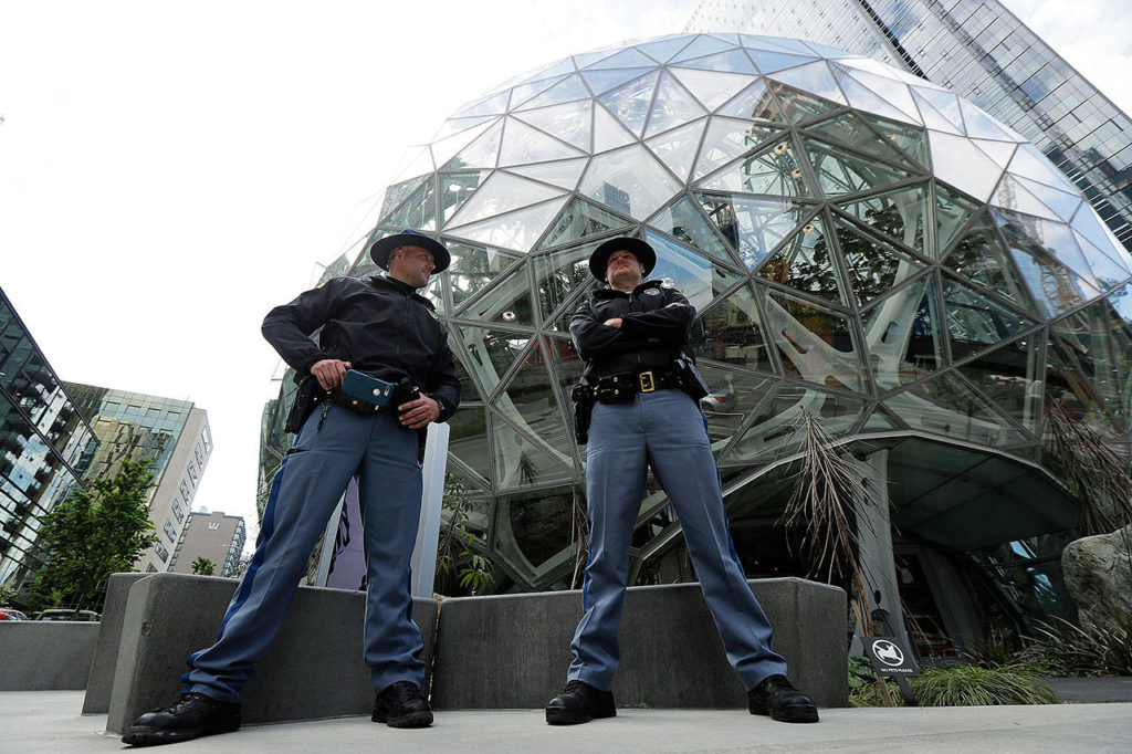 Two Washington State Troopers stand guard at the Amazon Spheres on May Day, Tuesday, in Seattle. The Seattle Police Department said on Twitter that a man was arrested earlier in the day for throwing a rock at the Spheres. (AP Photo/Ted S. Warren)

