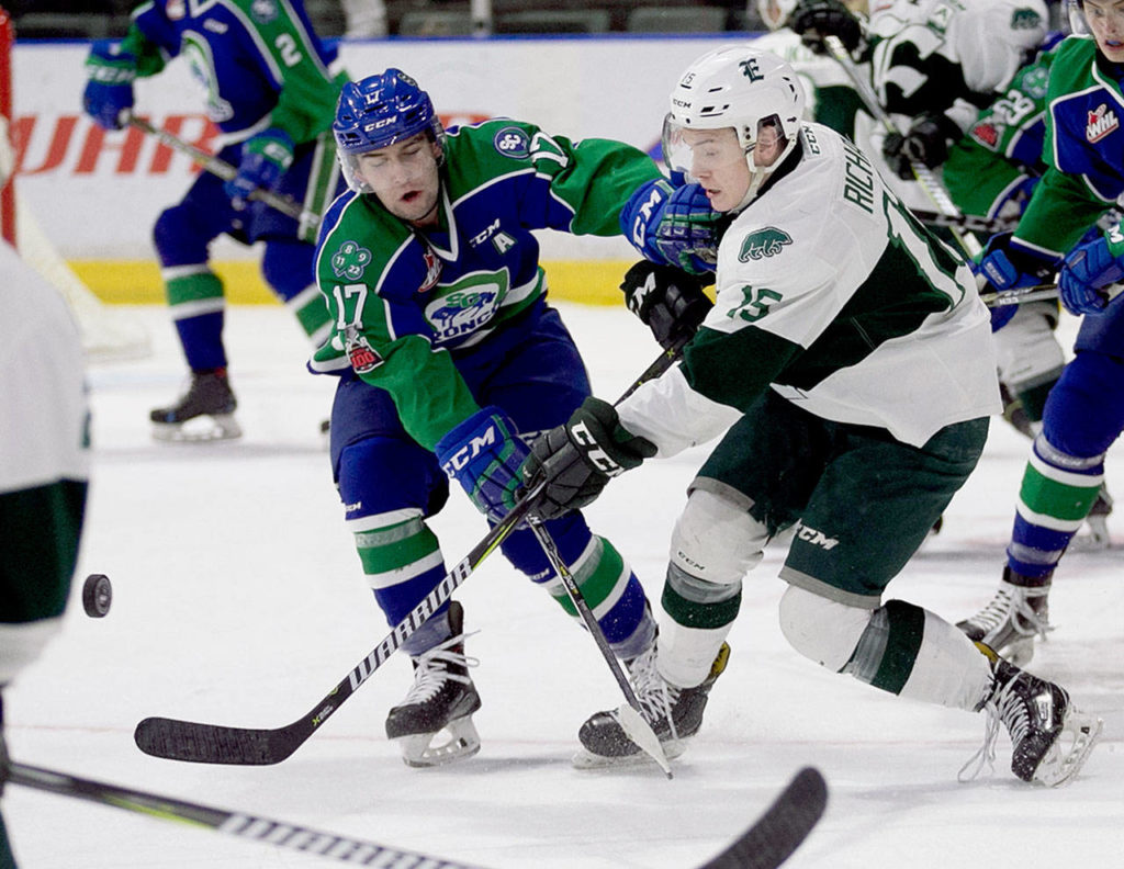 Swift Current’s Tyler Steenburgen and Everett’s Sean Richards vie for the puck Jan. 21 at Angel of the Winds Arena in Everett. The Silvertips won 4-1. (Kevin Clark / The Herald)
