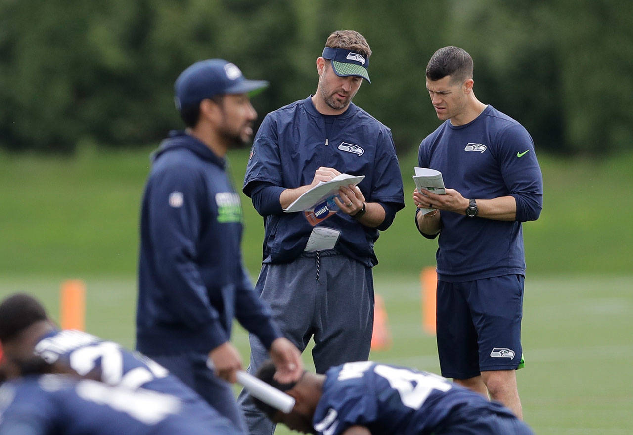 Seahawks offensive coordinator Brian Schottenheimer (center) confers with another coach during rookie minicamp on May 4, 2018, in Renton. (AP Photo/Ted S. Warren)