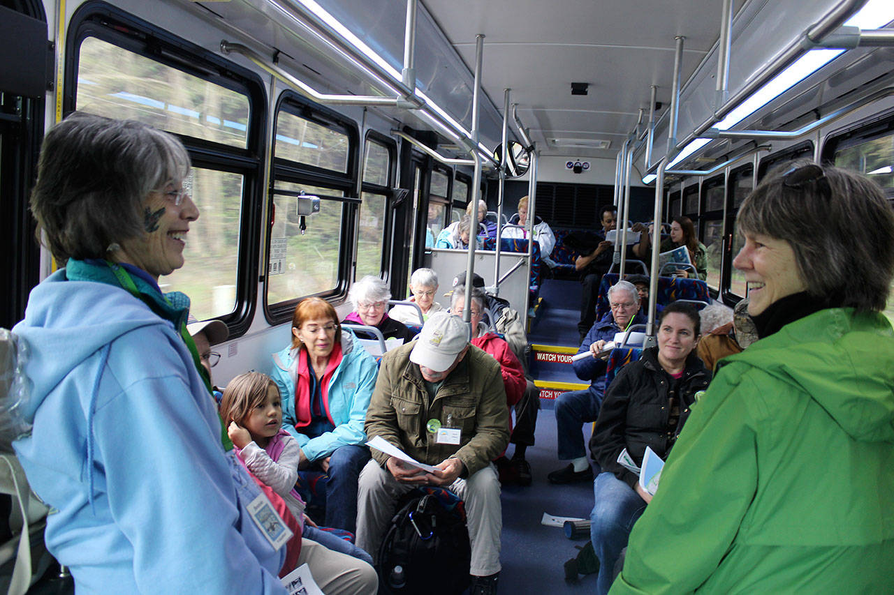 Island Transit, which now operates without collecting fares, may begin to do so. In this photo from April, Langley Whale Center guide Bonnie Gretz visits with people during a whale-themed tour on Whidbey Island. (Patricia Guthrie / South Whidbey Record)