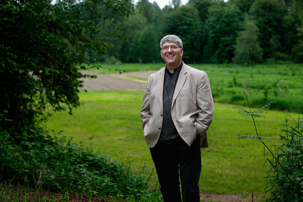 The Rev. Jay DeFolco, of Holy Cross Catholic Church of Lake Stevens and Granite Falls, is looking foreward to Sunday’s groundbreaking for a new church on their Lochsloy area land. Members grow thousands of pounds of potatoes in the rich soil, donating the spuds to food banks. (Dan Bates / The Herald)
