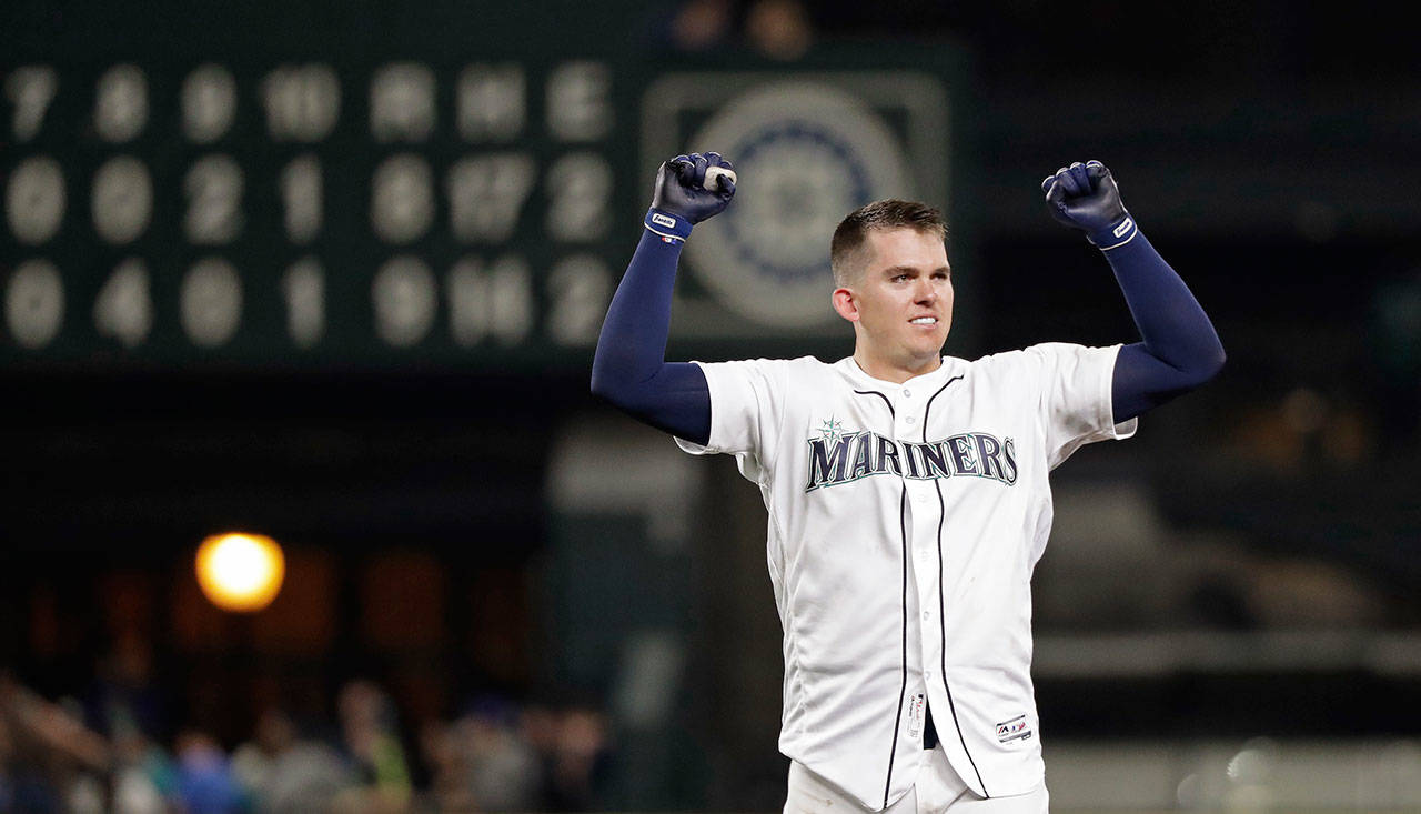 The Mariners’ Ryon Healy holds up his arms after driving in the winning run against the Angels in the 11th inning on May 5, 2018, in Seattle. (AP Photo/Elaine Thompson)