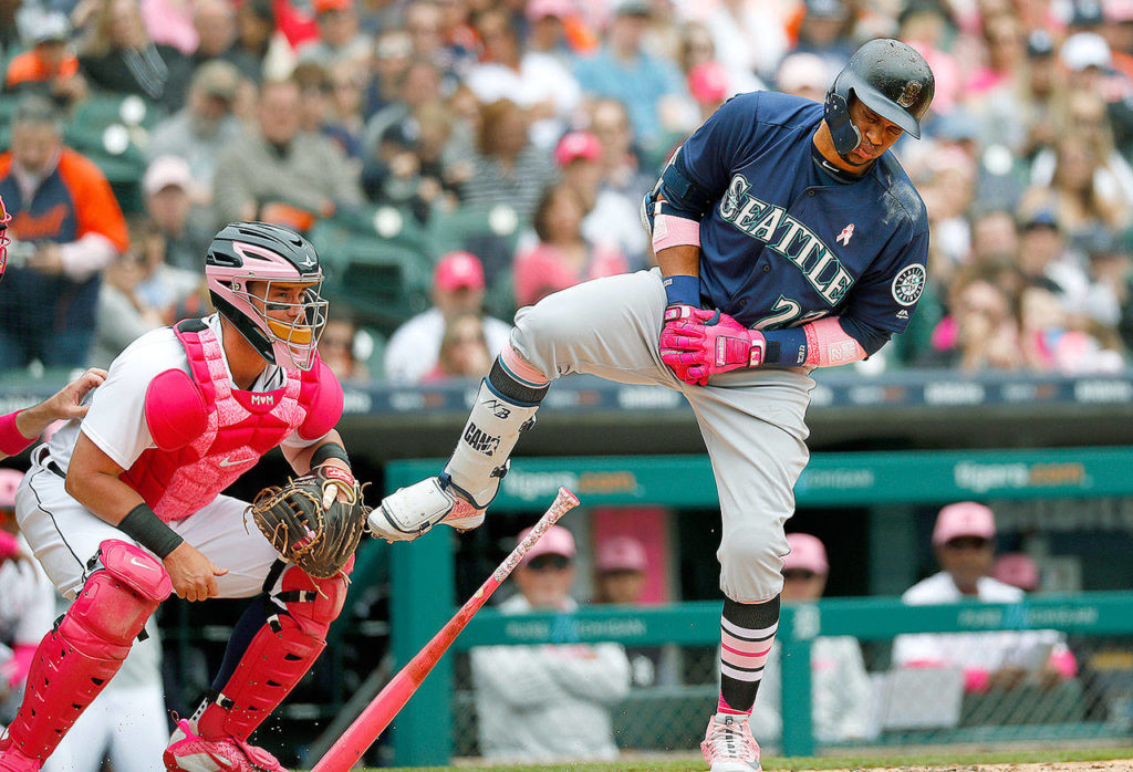 Seattle Mariners’ Robinson Cano (22) reacts to being hit on the hand by a Detroit Tigers relief pitcher Blaine Hardy pitch in the third inning of a baseball game as catcher James McCann looks on in Detroit, Sunday, May 13, 2018. (AP Photo/Paul Sancya)
