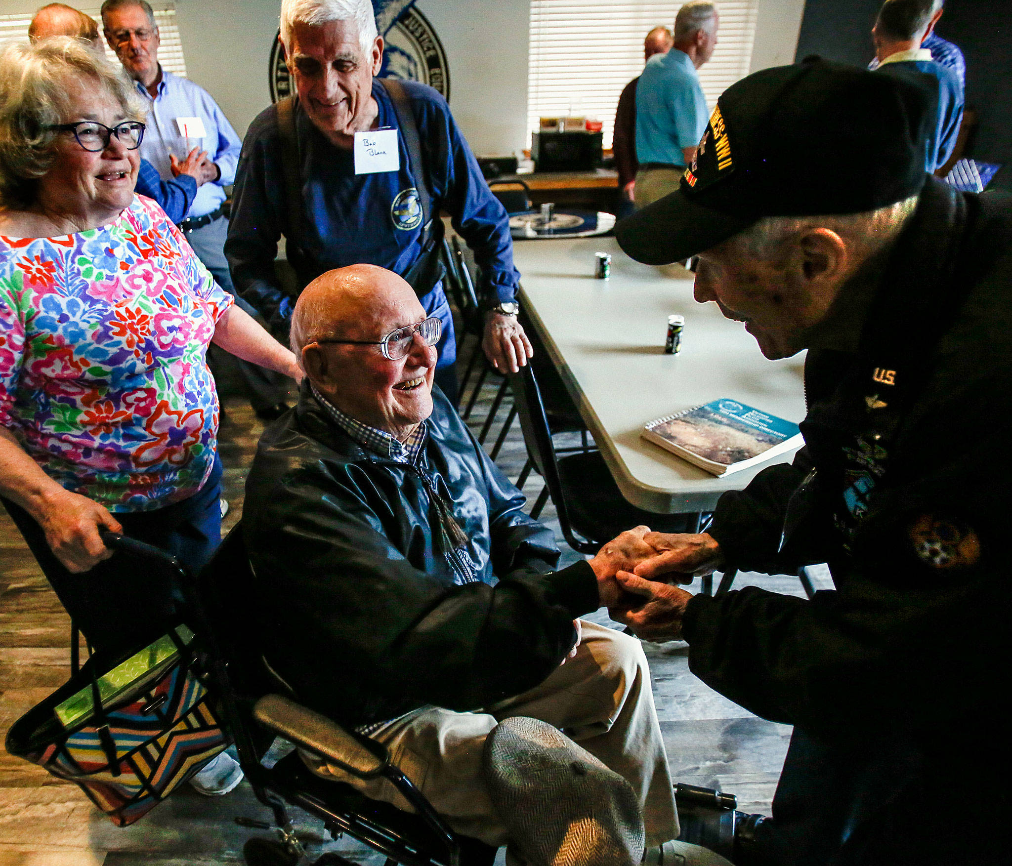 Dick Nelms, 95, enthusiastically shakes hands with Bob Jones, also in his 90s, upon meeting at the Stanwood Eagles on Thursday. More than 20 former military pilots gathered to hear Nelms speak of flying 35 combat missions in a B-17 during World War II. (Dan Bates / The Herald)