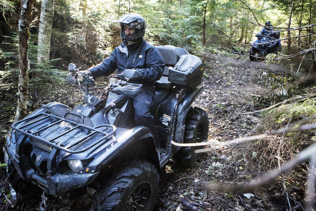 Brandon Deines (left), of Duvall, rides his ATV with Carl Teunissen (right), of Issaquah, at the Reiter Foothills Forest ORV Trails near Sultan on Oct. 26. (Ian Terry / Herald file)
