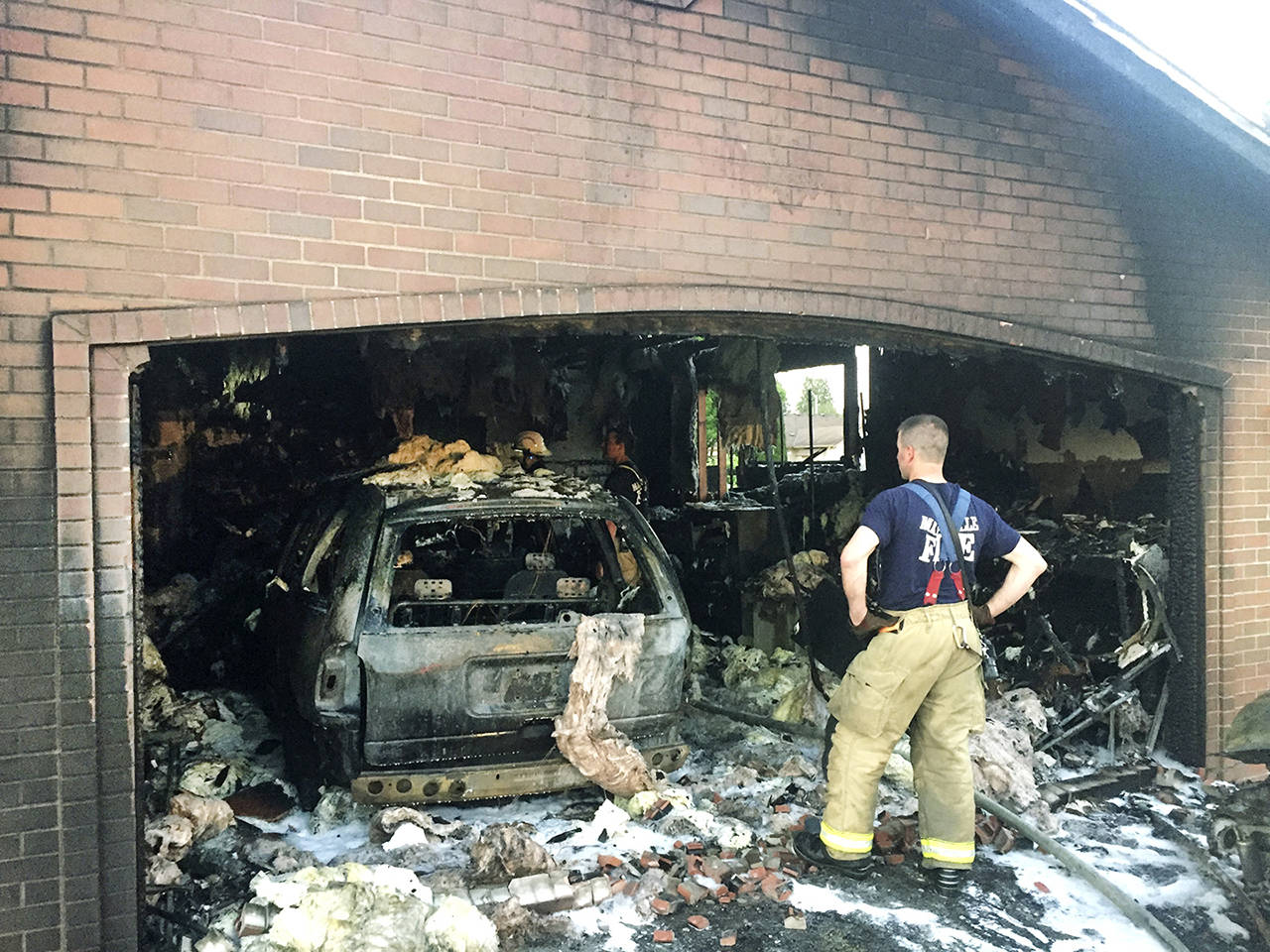 Firefighters inspect the garage of a home that was wrecked by fire Tuesday night in Marysville. (Marysville Fire District)