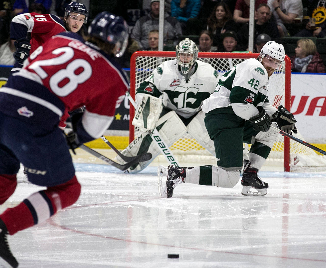 Tri-City’s Morgan Geekie (28) attempts a shot with the Silvertips’ Ondrej Vala (right) and goalie Carter Hart defending during a game on April 20, 2018, at Angel of the Winds Arena in Everett. (Kevin Clark / The Herald)