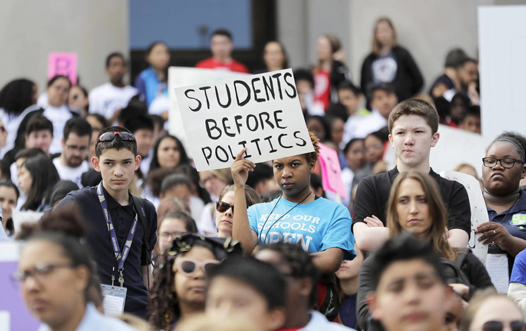 A student from Destiny Charter Middle School in Tacoma holds a sign that reads “Students Before Politics” during a rally held by charter school students, teachers, and supporters at the Capitol in Olympia on Thursday. (AP Photo/Ted S. Warren)
