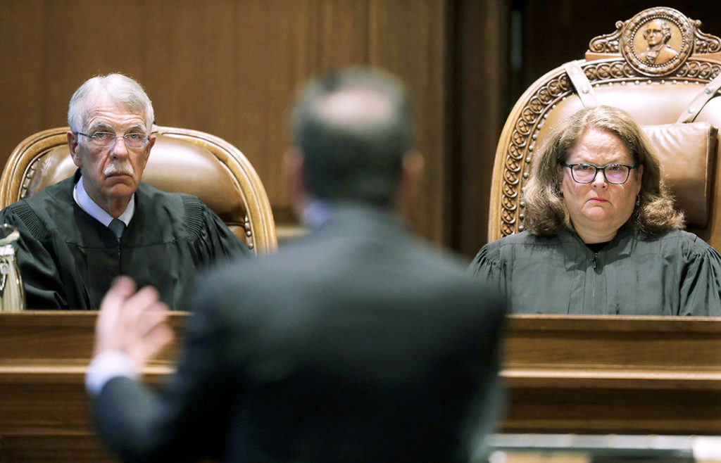 Washington Supreme Court Chief Justice Mary Fairhurst (right) and Associate Chief Justice Charles Johnson (left) listen Thursday as Paul Lawrence (center), an attorney representing teachers unions and other groups who have sued over Washington state’s 2016 charter school law, presents an argument in Olympia. (AP Photo/Ted S. Warren)
