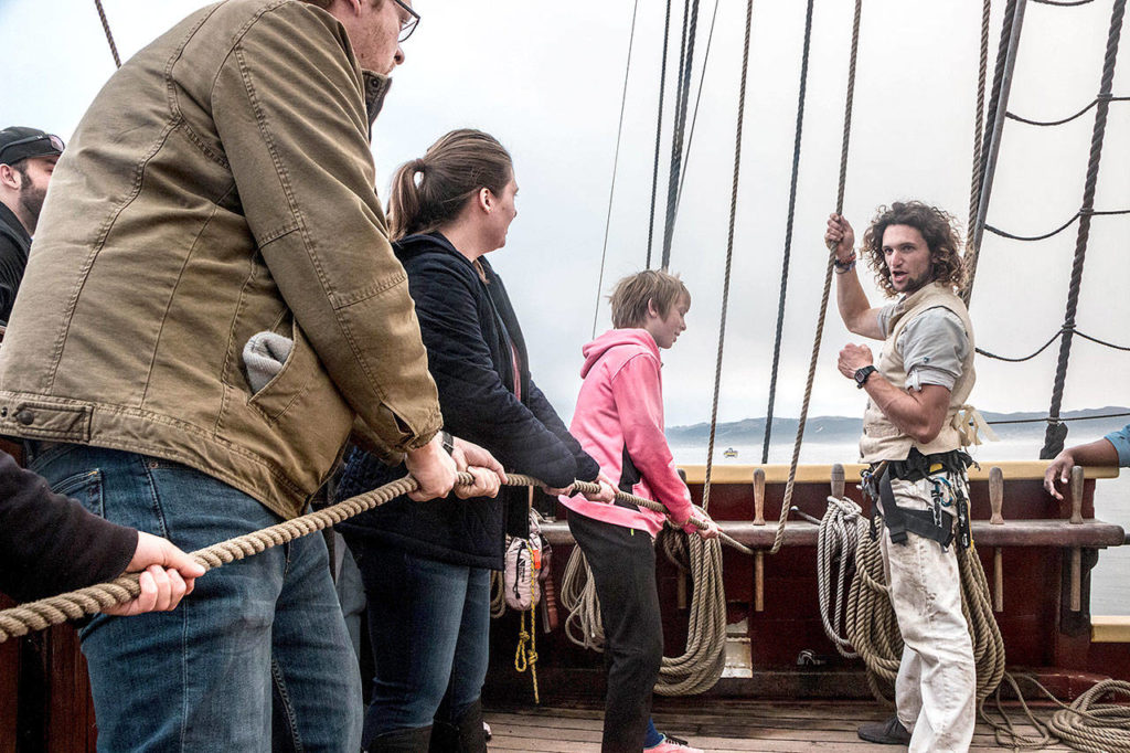 Crew members will show passengers how to help steer tall ships during adventure sails aboard Lady Washington and Hawaiian Chieftain May 27 and May 28 in Puget Sound. (Rick Horn)
