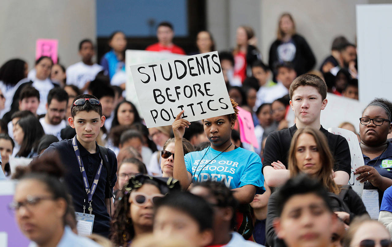 A student from Destiny Charter Middle School in Tacoma, holds a sign that reads “Students Before Politics,” during a rally held by charter school students, teachers and supporters at the Capitol in Olympia, Thursday. Teachers unions and other groups have sued over Washington state’s 2016 charter school law, which was enacted after the justices struck down the old law as unconstitutional. (Ted S. Warren/Associated Press)