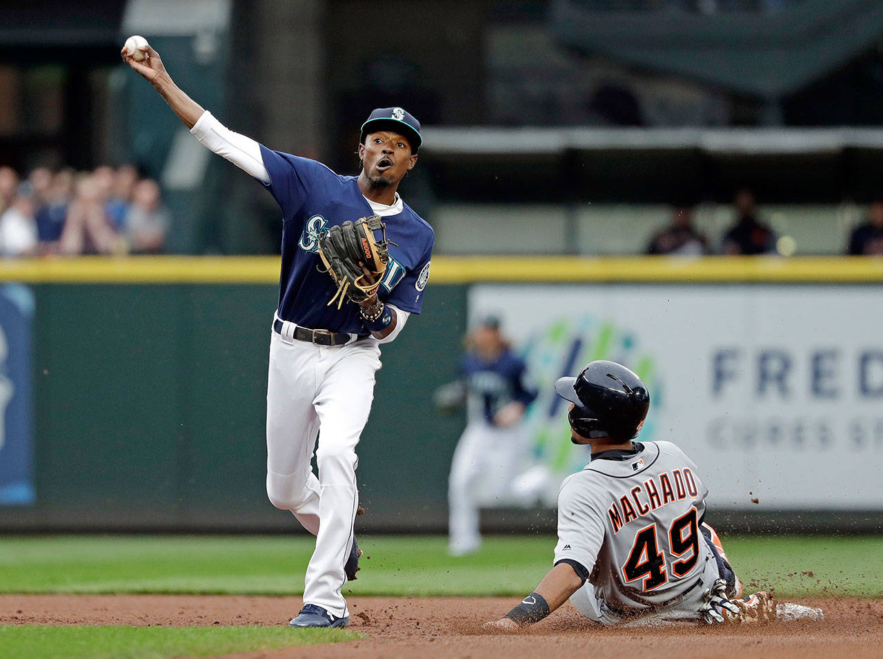 Seattle’s Dee Gordon hrows to first base after forcing out Detroit’s Dixon Machado at second base during the second inning of Friday’s game at Safeco Field. (AP Photo/Elaine Thompson)