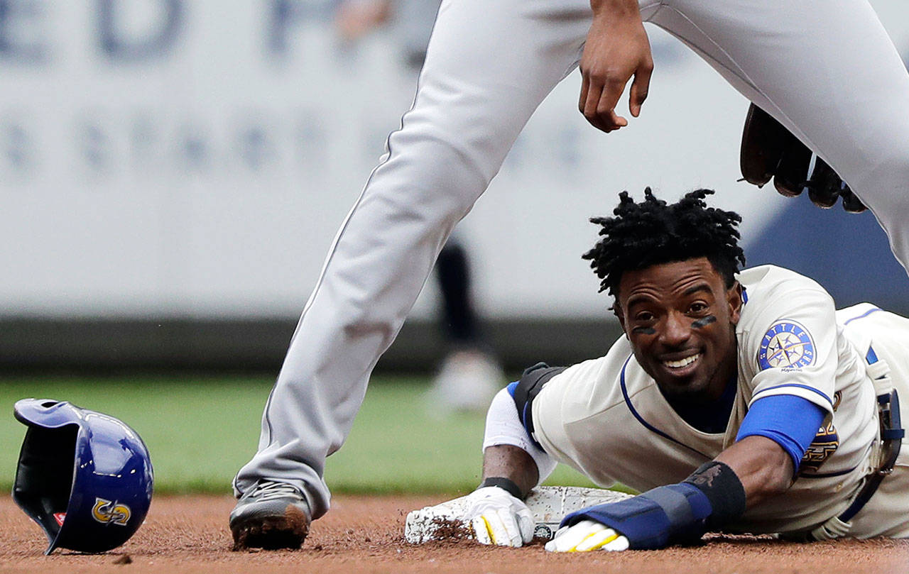 Dee Gordon of the Seattle Mariners loses his helmet on a slide at second base during the first inning of Sunday’s game at Safeco Field. (AP Photo/Ted S. Warren)