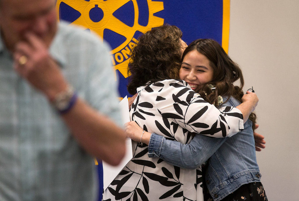 Cascade High’s Thi Vu is hugged by Jan Jensen after receiving the Brett Akio Jensen Scholarship at the Rotary Club of Everett’s annual scholarship awards held at the Everett Public Schools Community Resource Center on Monday in Everett. Don Jensen (left) and Jan gave a scholarship in their son’s name. (Andy Bronson / The Herald)

