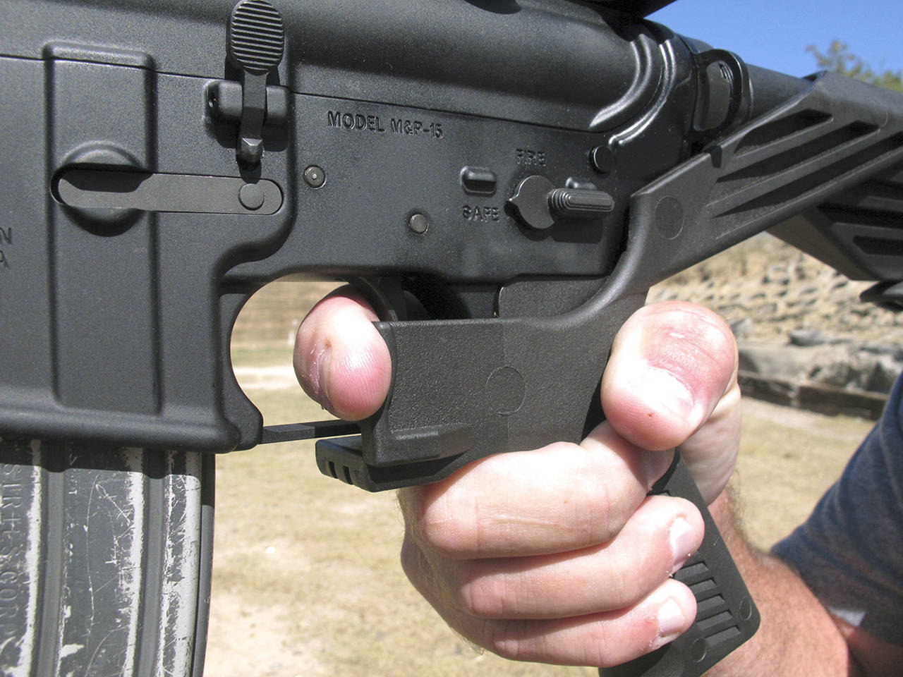 Shooting instructor Frankie McRae demonstrates the grip on an AR-15 rifle fitted with a bump stock at his 37 PSR Gun Club in Bunnlevel, North Carolina. Some states, including Washington, and cities are taking the lead on banning bump stocks. (Allen G. Breed / AP file)