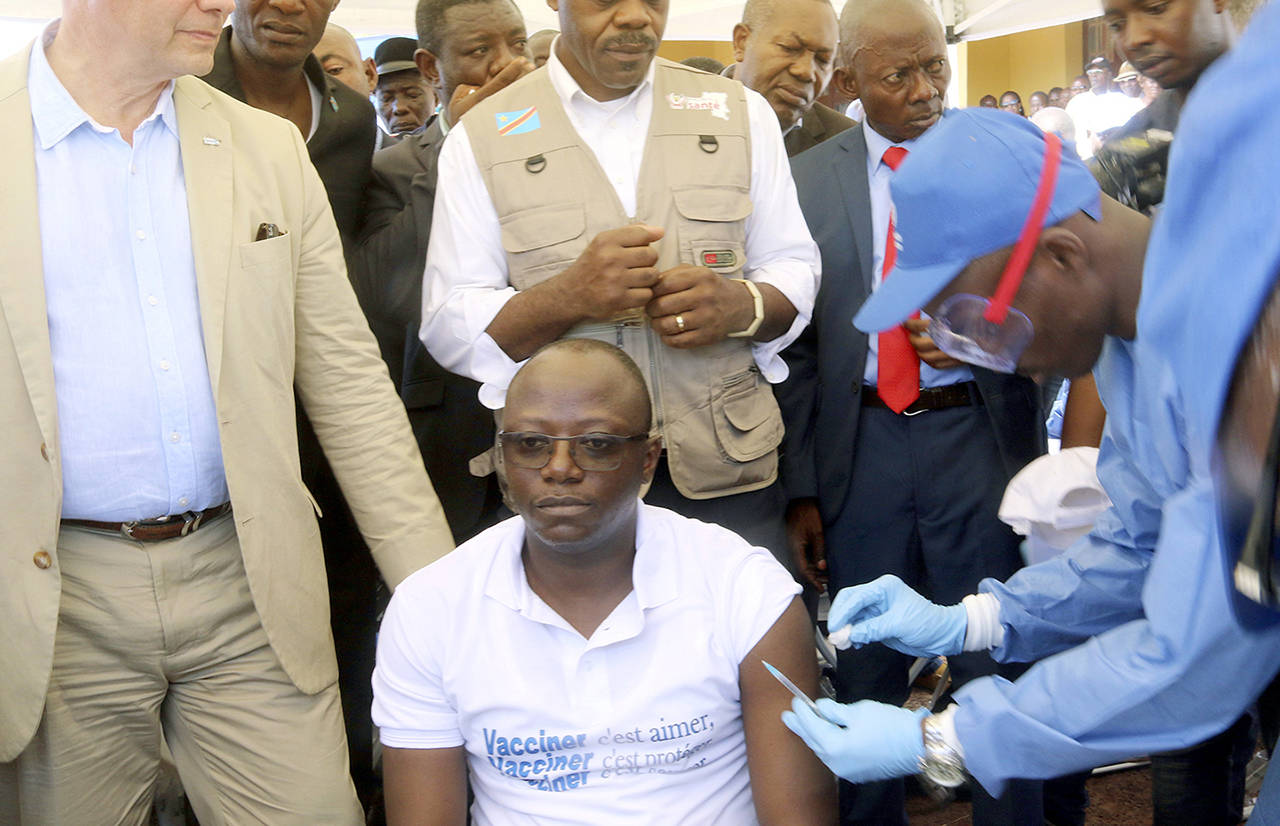 Dr. Guyauma Ngoyi Mwamba (center), representative of the Democratic Republic of Congo on Expanded Program on Immunization, is administered with a vaccine during a vaccination campaign in Mbandaka, Congo on Monday. (AP Photo/John Bompengo)