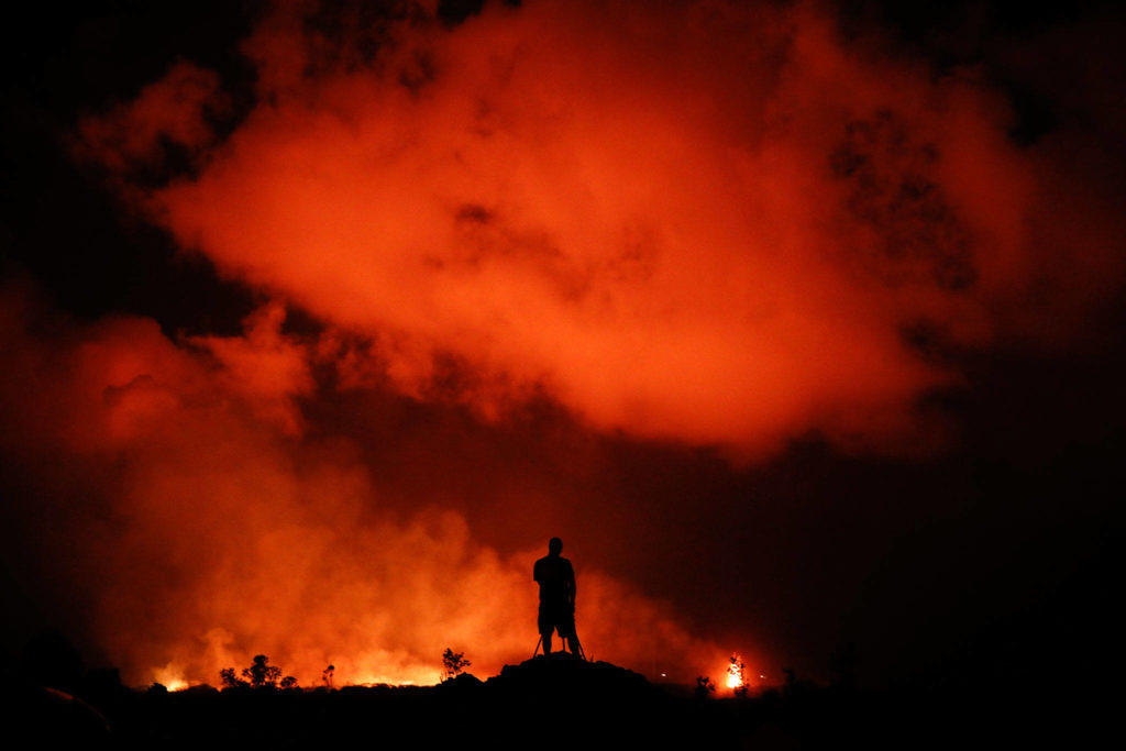 Peter Vance, 24, photographs lava erupting in the Leilani Estates subdivision near Pahoa, Hawaii on May 18. (AP Photo/Jae C. Hong,)
